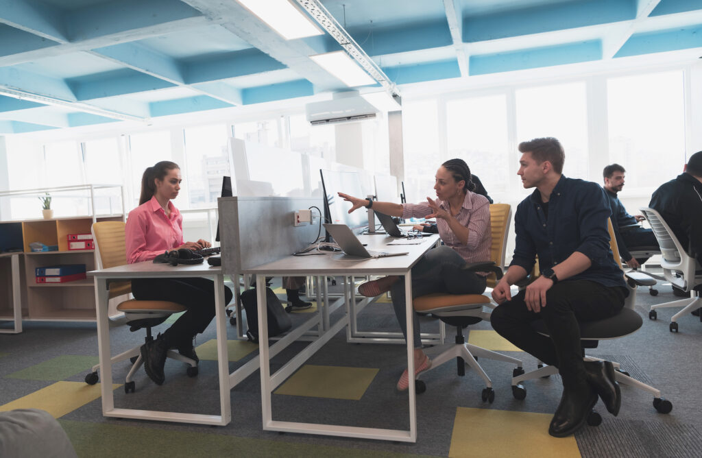 Collaborative process of multicultural skilled young business team during brainstorming meeting in office.Diverse group of young people dressed in formal wear cooperating on developing design project. High quality photo